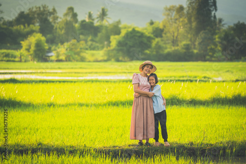 Mother and daughter travel in rice field on sunset  lovely family in beautiful nature background