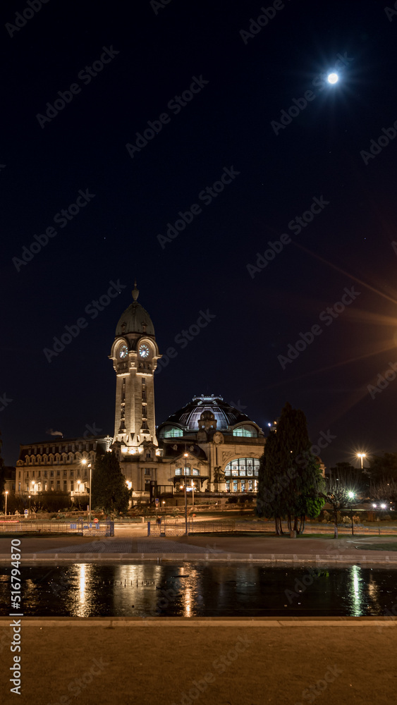 Limoges train station at night with moon, France, vertical picture