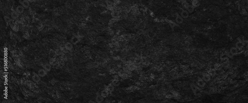 Black abstract lava stone texture background, dark black rough grainy stone or concrete wall texture background, black background with faint texture and bright center and black vignette border.	