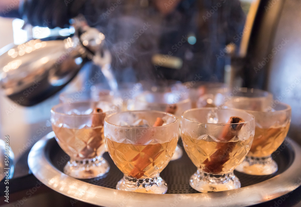 A tray of hot toddies being poured with steam rising