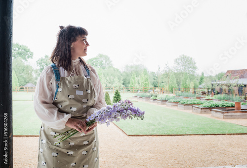 beautiful florist stood holding flowers in a country garden photo