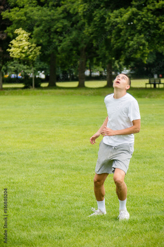 A Nineteen Year Old Teenage Boy Playing Football in A Public Park