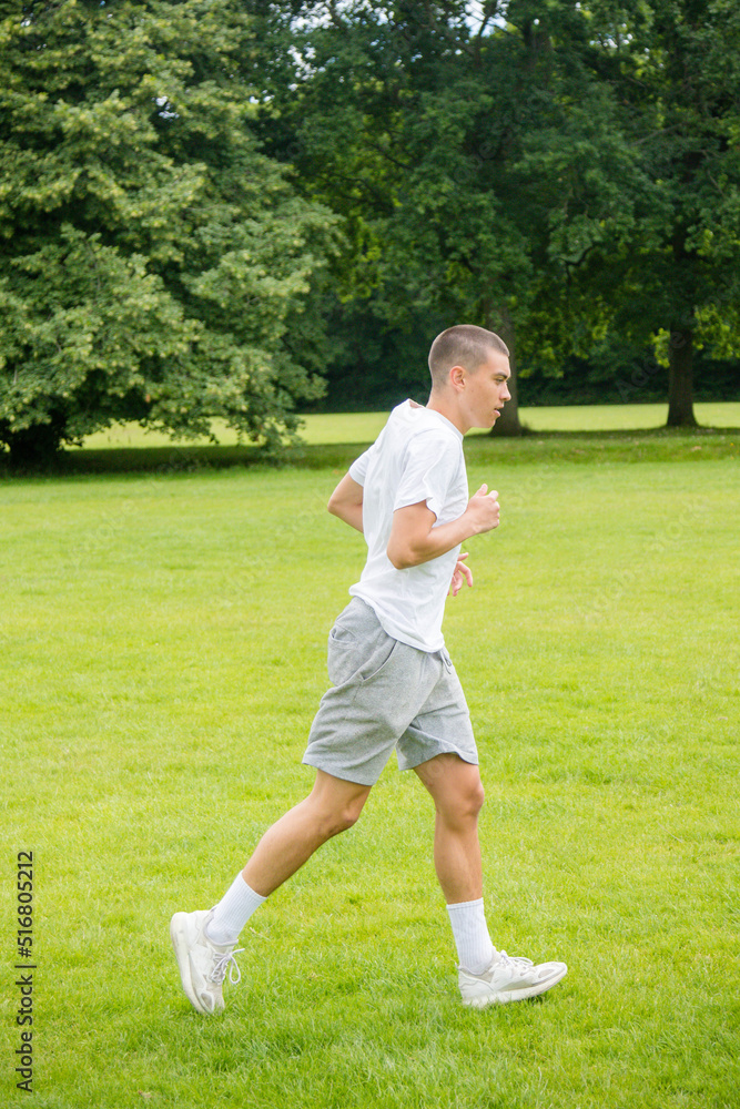 A Nineteen Year Old Teenage Boy Playing Football in A Public Park A Nineteen Year Old Teenage Boy Playing Football in A Public Park