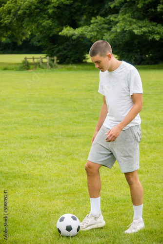 A Nineteen Year Old Teenage Boy Playing Football in A Public Park