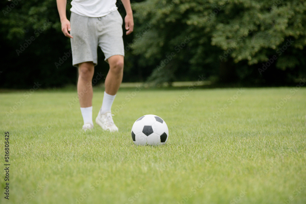 A Nineteen Year Old Teenage Boy Playing Football in A Public Park A Nineteen Year Old Teenage Boy Playing Football in A Public Park