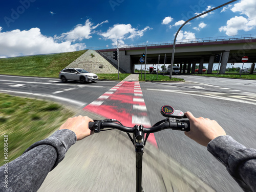 Fotografie Electric scooter fast ride through bike pathway in the city - first-person view