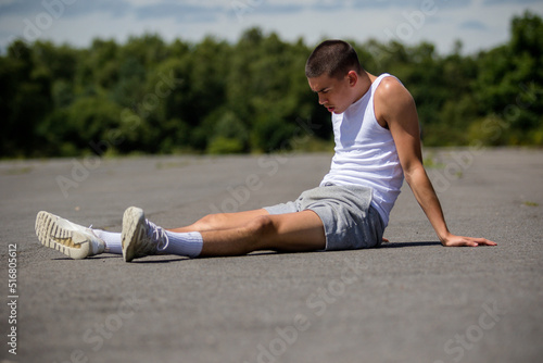 A Nineteen Year Old Teenage Boy Doing Situps In A Public Park