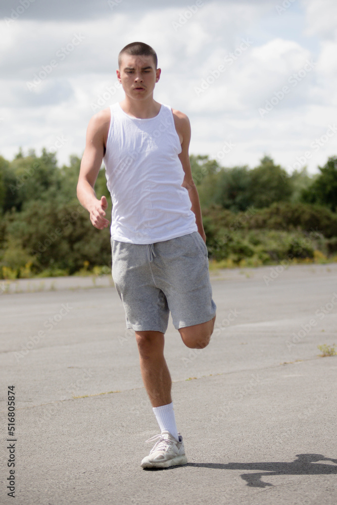 A Nineteen Year Old Teenage Boy Stretching In A Public Park A Nineteen Year Old Teenage Boy Stretching In A Public Park
