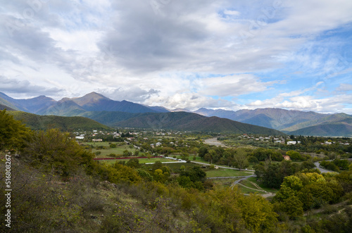 Panoramic view from the height of the hill to the Gremi village in Alazani valley and Caucasian Mountains in the distance. Georgia