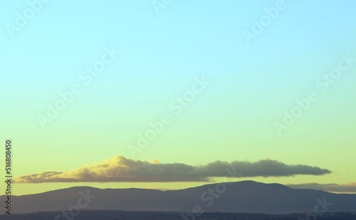 Sierra de Guadarrama vista desde el norte de la ciudad de Madrid, España. Fondo natural donde se puede ver la silueta de las montañas y las nubes con los últimos rayos del sol del día.