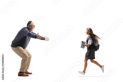 Full length profile shot of a schoolgirl running towards a mature man