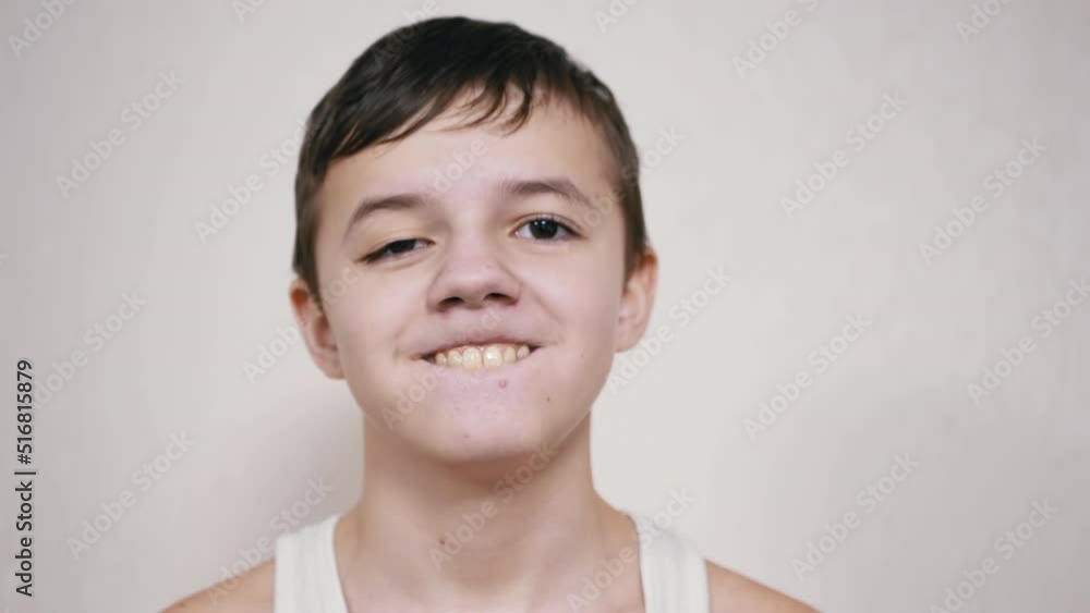 Smiling Teenager Gesticulates with Mouth, Showing his Teeth, Tongue. A