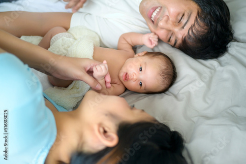 Smiling young mother and father with a new born baby, family and love concept