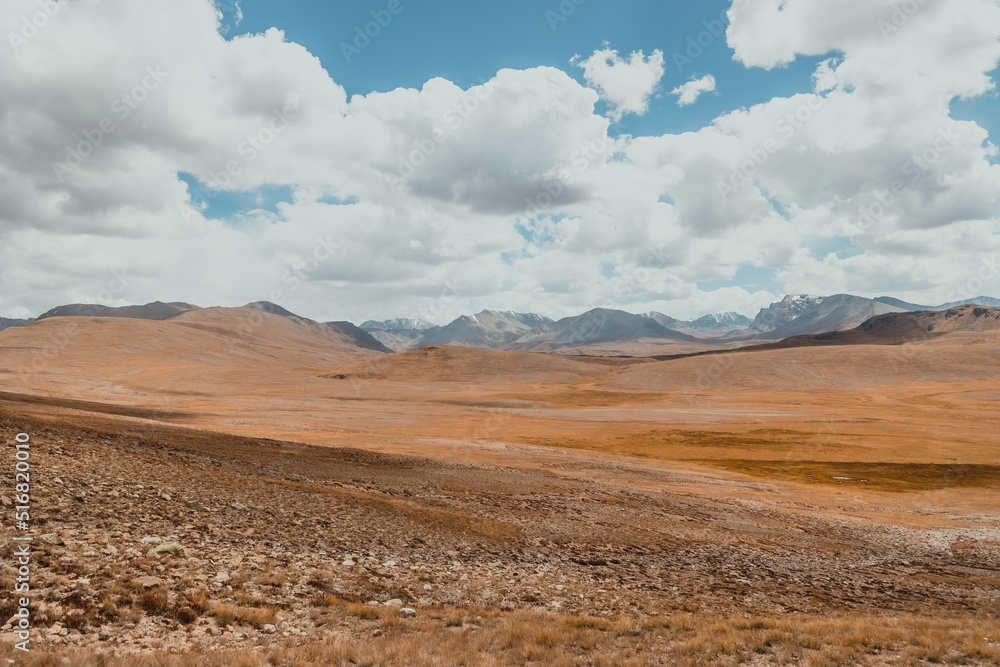empty valley of Deosai National Park with vast mountain range in northern Pakistan on sunny day