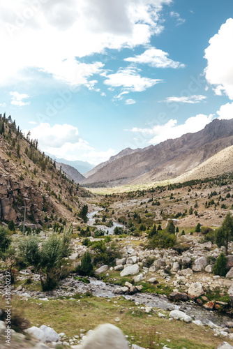 natural river flowing through a rocky mountain ravine in Astore Valley Pakistan on sunny summer day