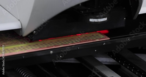 Close up of automated visual optical inspection system with red illumination for quality control of circuit board. Industrial, robotic, measurement, production, technology and manufacturing concept.