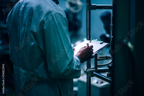 Close up man scientist in lab coat, researcher working in laboratory at night, Chemical lab test on cannabis oil, CBD, THC, alternative medical, Pharmaceutical industry.