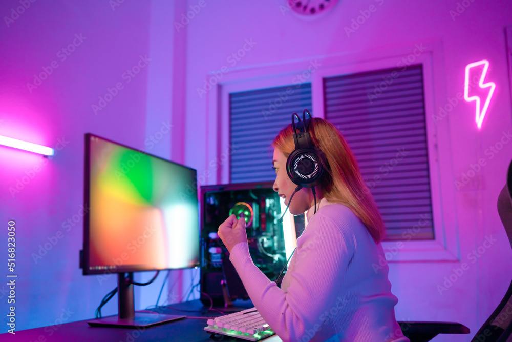 A Professional female pro gamer play online video games cyber sport and esport winner emotion. Young woman in tournament match worldwide in room colorful neon lights. A Professional female pro gamer play online video games cyber sport and esport winner emotion. Young woman in tournament match worldwide in room colorful neon lights.