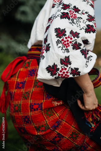 Part of Ukrainian traditional national costume closeup: embroidered shirt, vyshyvanka, skirt, woven belt. Culture of Ukraine