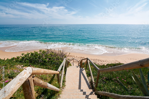 Beach with access from a wooden staircase without persons photo