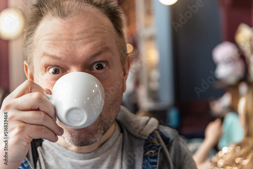 One man drinking coffee with fun mood.