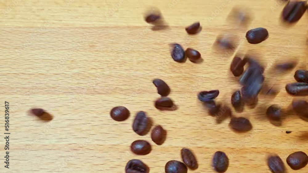 Coffee beans fall onto a wooden table from above with different angles and tracking shots. Coffee beans fall onto a wooden table from above with different angles and tracking shots.