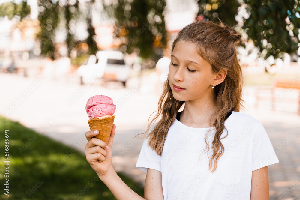 Happy child girl with ice cream cone in summer park. Attractive girl holding sweets ice cream cone and smiling. Happy child girl with ice cream cone in summer park. Attractive girl holding sweets ice cream cone and smiling.