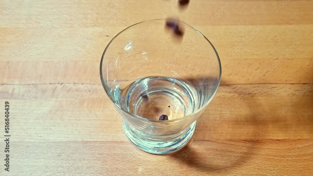Coffee beans fall into a glass from above with different angles Coffee beans fall into a glass from above with different angles