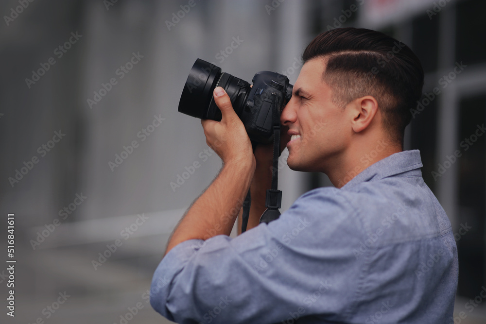 Photographer taking picture with professional camera on city street Photographer taking picture with professional camera on city street