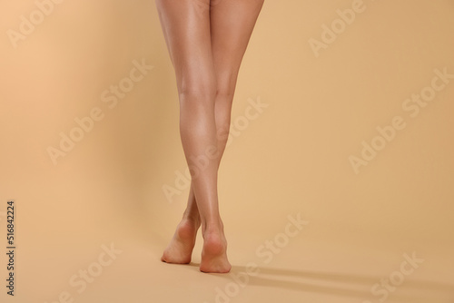 Woman with beautiful long legs on beige background, closeup © New Africa