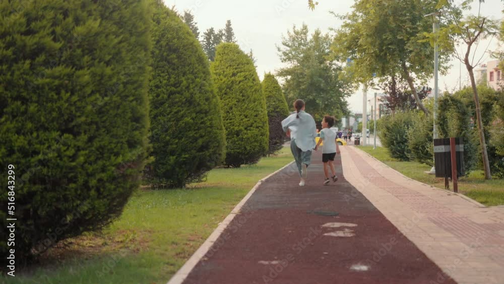 Back view of preschooler and mom running along the alley Back view of preschooler and mom running along the alley