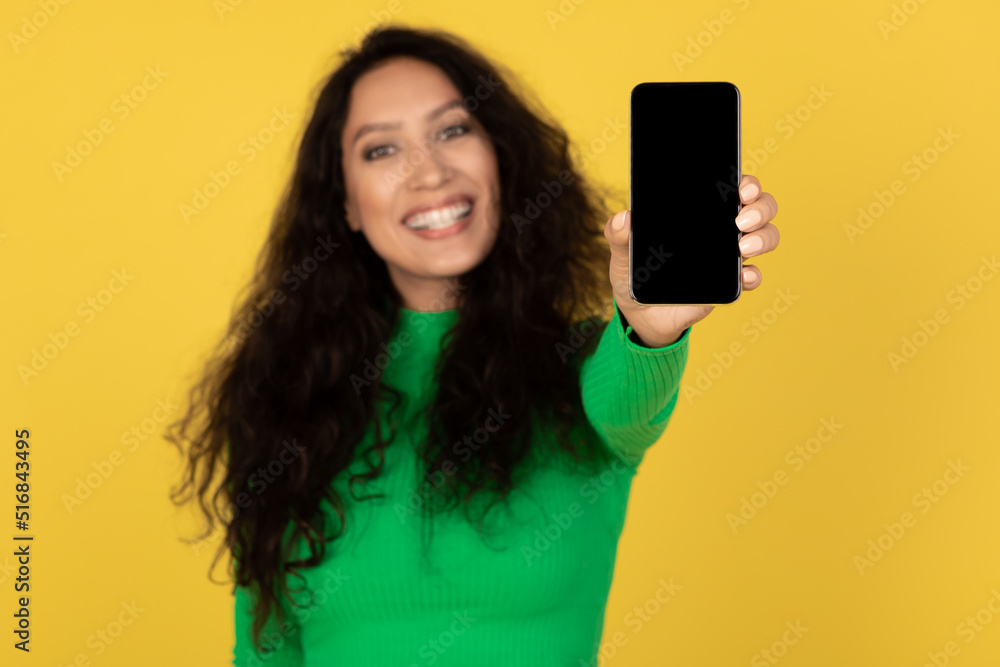 Happy Arabic Female Showing Phone With Empty Screen, Yellow Background Happy Arabic Female Showing Phone With Empty Screen, Yellow Background