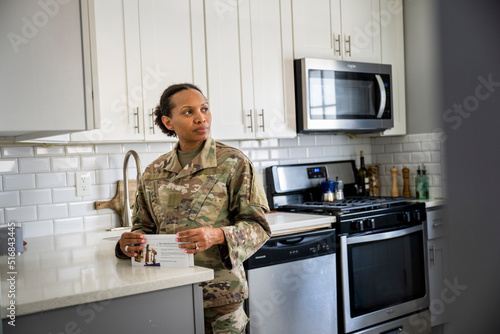 Fotografija U.S. Army female soldier opening her mail in her kitchen
