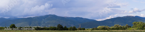 Thunderhead covers the Balkans. Downpour is approaching agricultural land. Villages, fields and forests of Bulgaria before the rain. The terrain in southern Europe. Panorama. © Piotr