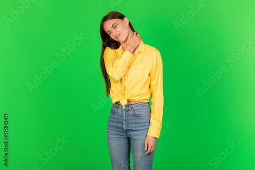 Unhappy Lady Touching Aching Neck Standing Over Green Studio Background