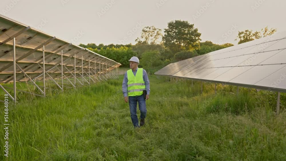Full length view of male engineer in uniform walking at solar power plant Full length view of male engineer in uniform walking at solar power plant