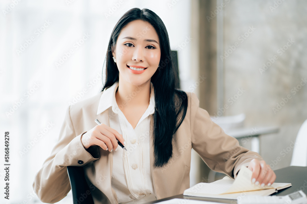 Young asian businesswoman beautiful charming smiling and talking on the mobile phone in the office Young asian businesswoman beautiful charming smiling and talking on the mobile phone in the office