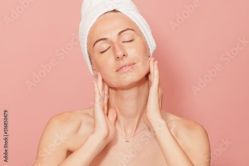 Woman with patches under her eyes touching her smooth skin