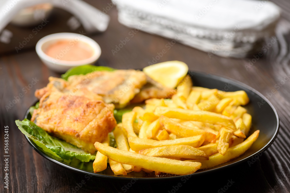 fish and chips on a black plate fish and chips on a black plate