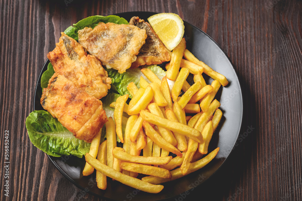 fish and chips on a black plate fish and chips on a black plate