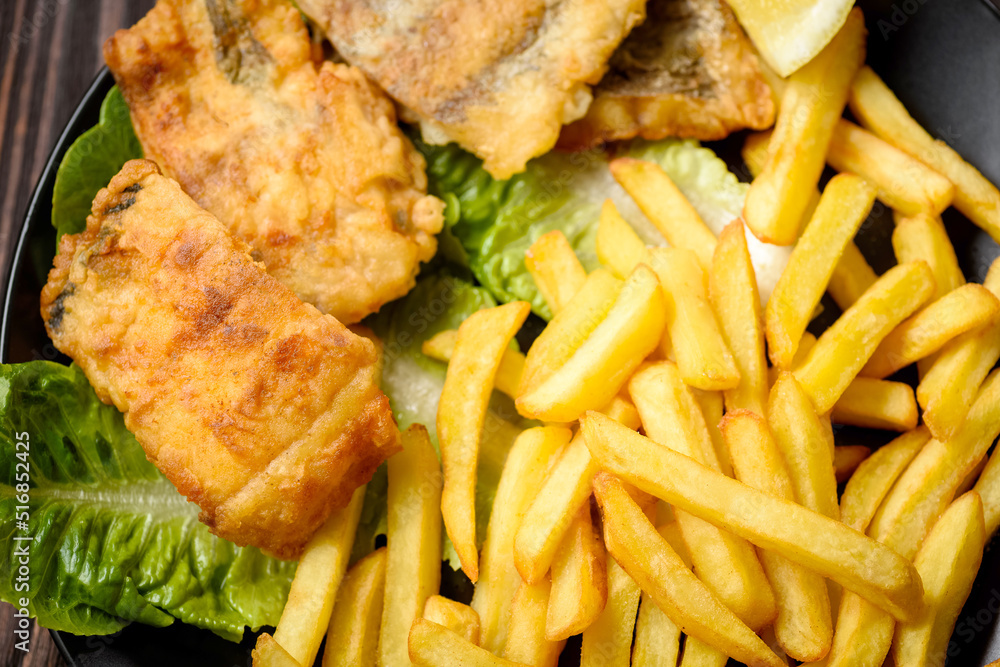 fish and chips on a black plate fish and chips on a black plate