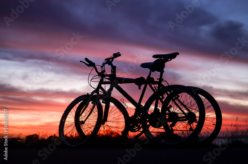 Silhouette of two bikes at sunset time by Guaiba Lake in Porto Alegre, Rio Grande do Sul, Brazil