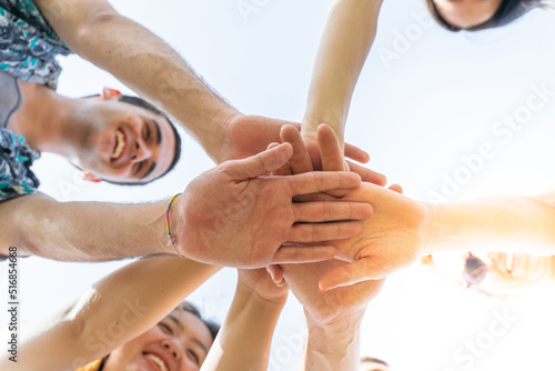 Teamwork, unity concept, group of friends put their hands together. © deliris