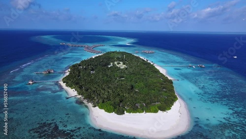 Tropical atoll island in Maldives with coral reef and turquoise sea water. Touristic vacation holidays travel destination. Scenic seascape. Drone aerial video footage. Vakkaru, Maldives..