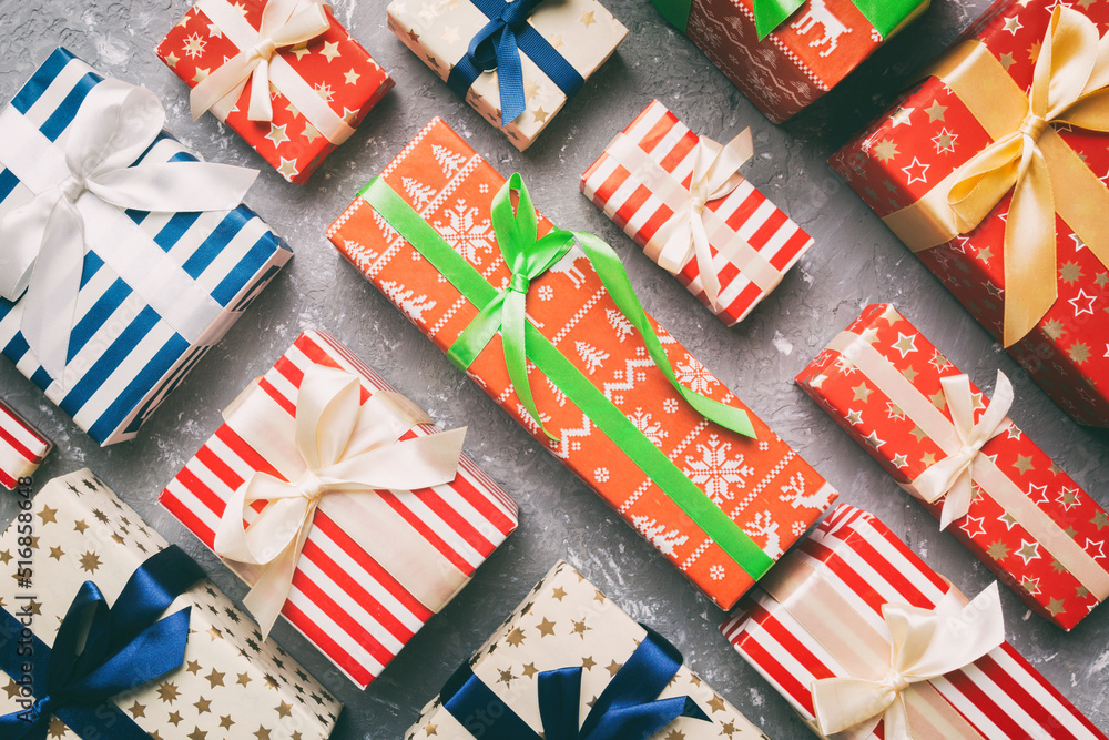 Fototapeta premium A lot of Christmas gift boxes in colored paper decorated on table, Top view close up. Many present New Year gift