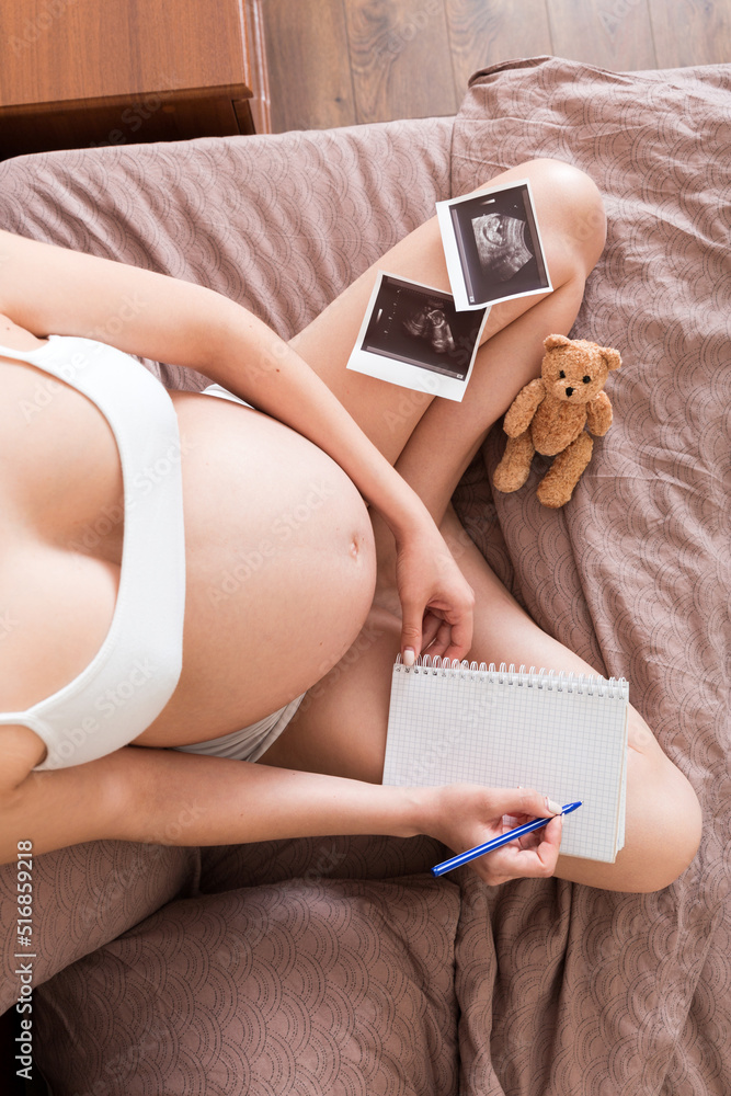 Top view caring future mother writing diary with ultrasound. pregnant woman  tummy making notes feeling during pregnancy or creating scrapbook Stock  Photo | Adobe Stock