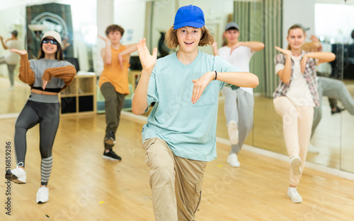Youth boys and girls performing hip-hop dance in ballroom.