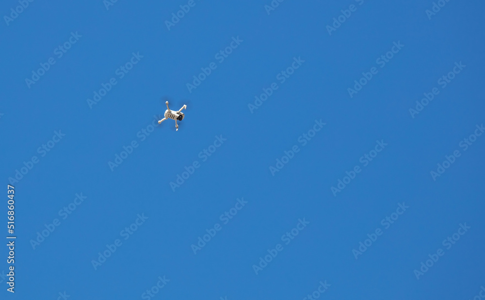 Drone flying in blue sky.
