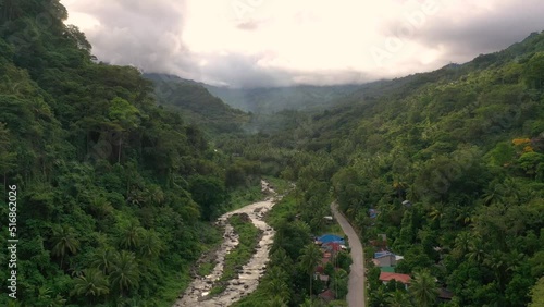 Drone footage of a scenic valley in a tropical rainforest with river and road at the bottom of rolling mountains in South east Asia. With copy space. photo