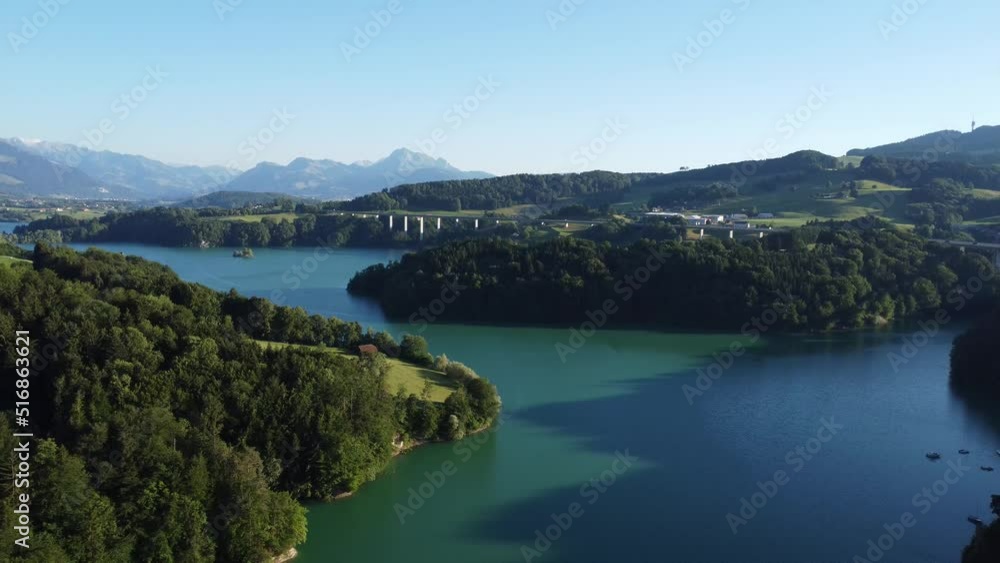 view over the imposing lac de gruyere with a motorway bridge and the Swiss mountains in the background, idyllic light in the evening view over the imposing lac de gruyere with a motorway bridge and the Swiss mountains in the background, idyllic light in the evening